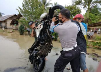 Inilah Sosok Polisi yang Bantu Evakuasi Warga Terdampak Banjir di Dumoga